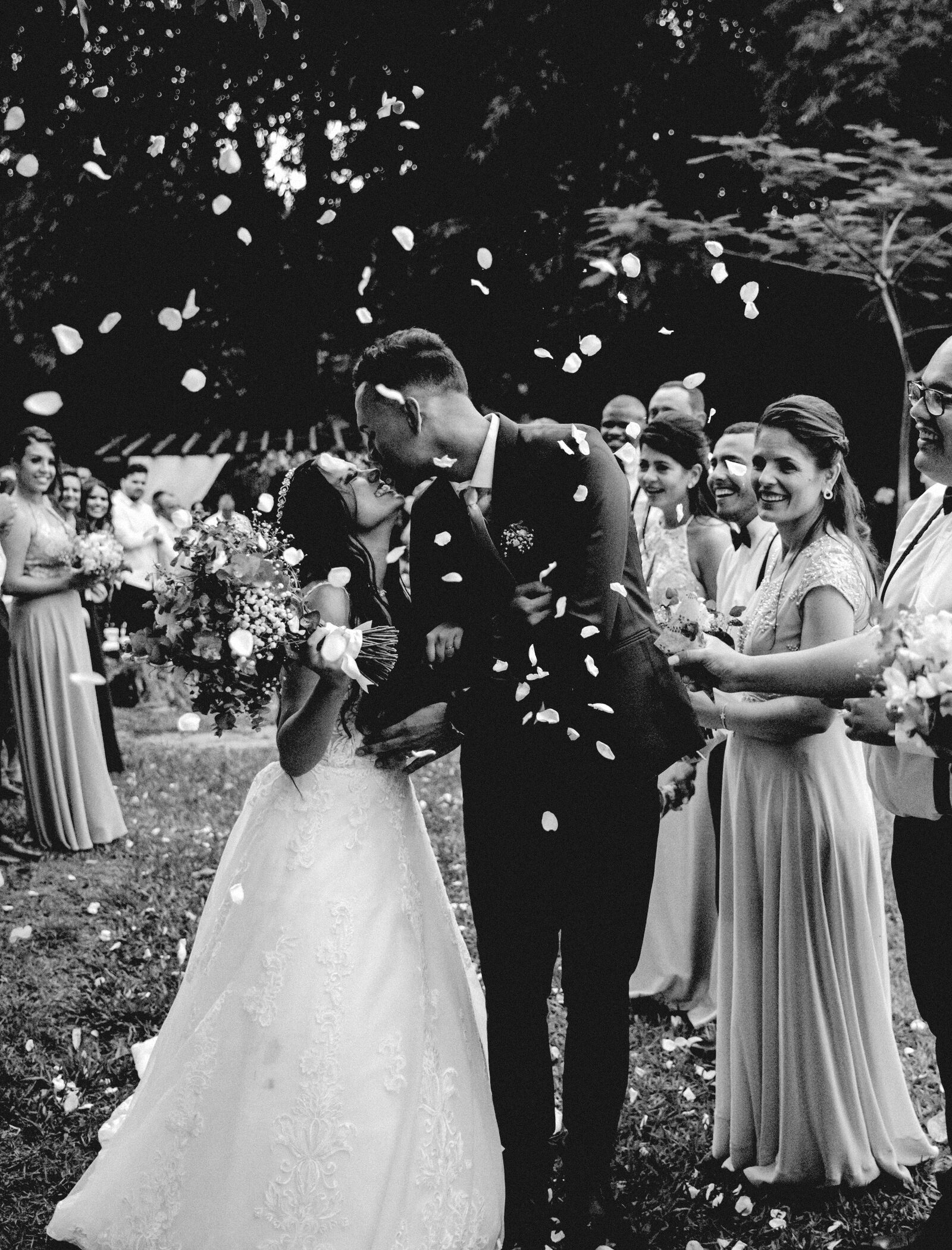 A couple leaving their ceremony through a shower of confetti thrown by guests