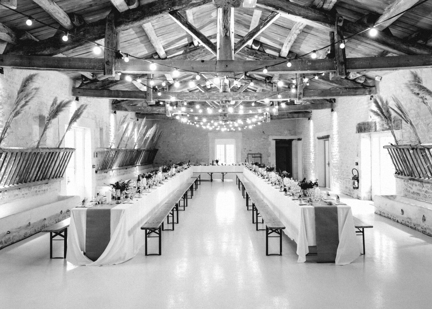 A long dining hall set for a banquet under warm light