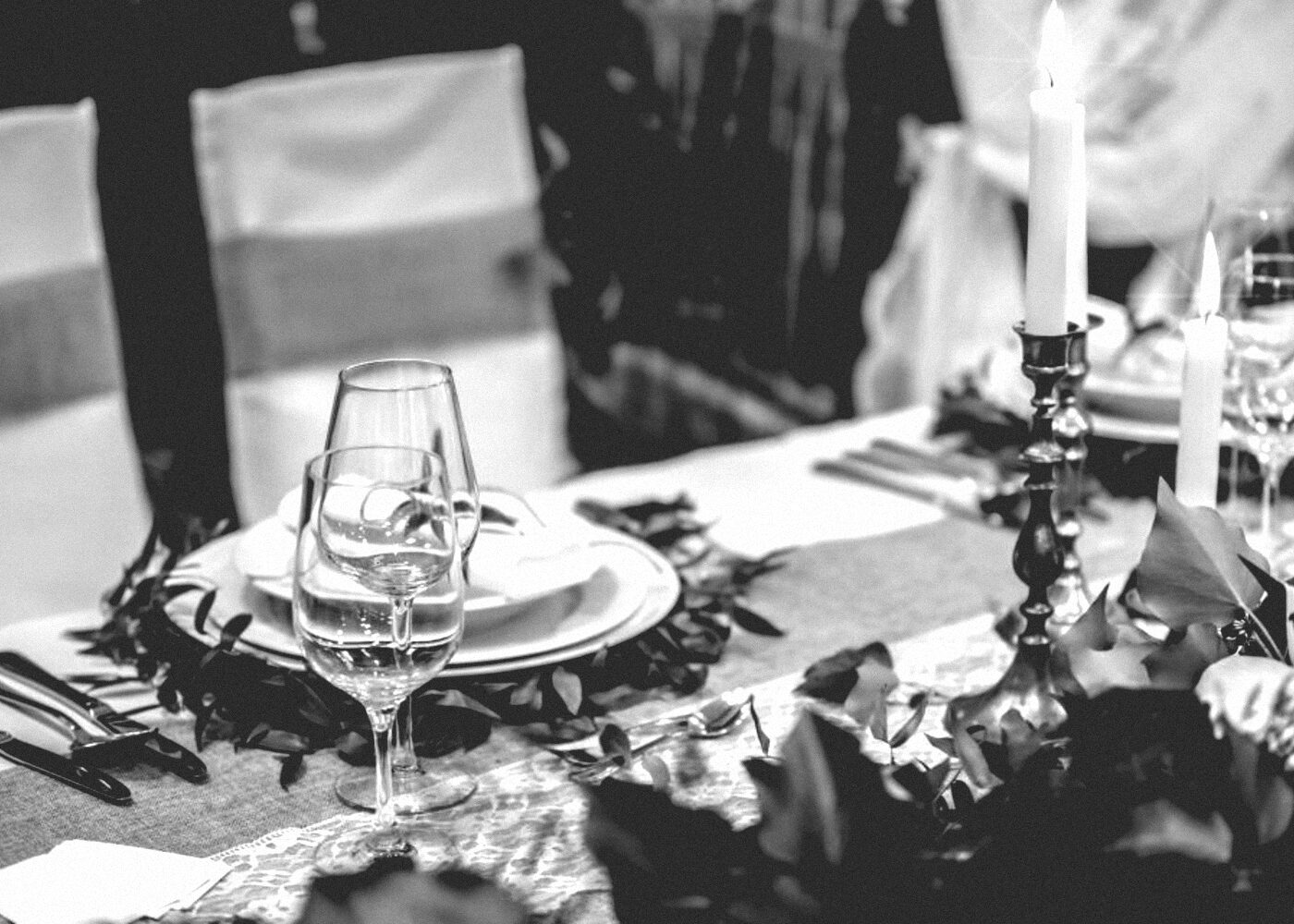 A round banquet table laid with glassware and a low centrepiece